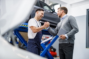 mechanik samochodowy i klient podają sobie ręce